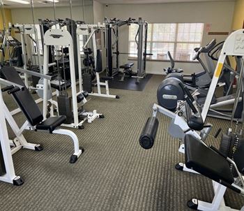 A gym with a variety of equipment including weights and machines.